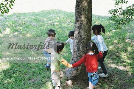 Children Playing Near Tree Trunk