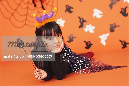 Jeune fille en Costume pour l'Halloween, tenant la baguette magique