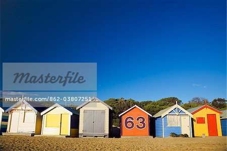 Australia, Victoria, Melbourne.  Colourful beach huts at Brighton Beach.