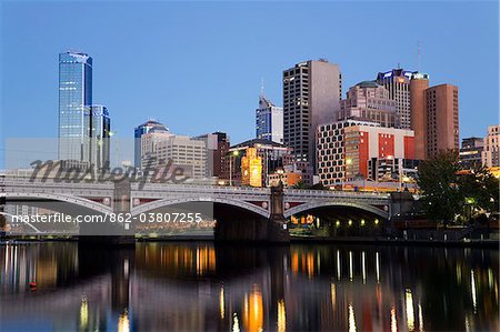 Australia, Victoria, Melbourne.  Princes Bridge on the Yarra River, with the city skyline at dusk.