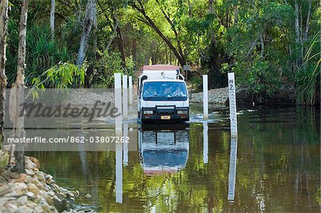 Australia, Northern Territory, Kakadu National Park.  A four wheel drive vehicle crosses Jim Jim Creek.
