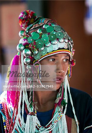 Myanmar, Burma, Keng Tung (Kyaing Tong). Young Akha girl wearing beautiful headdress decorated with silver coins and baubles, visiting Keng Tung market.