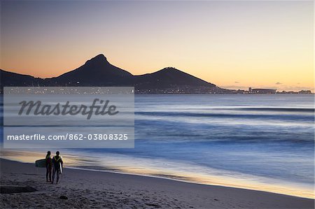 Surfer am Strand von Milnerton mit Lion's Head und Signal Hill im Hintergrund, Cape Town, Western Cape, Südafrika