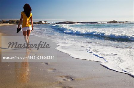 Woman walking on Camps Bay beach, Cape Town, Western Cape, South Africa