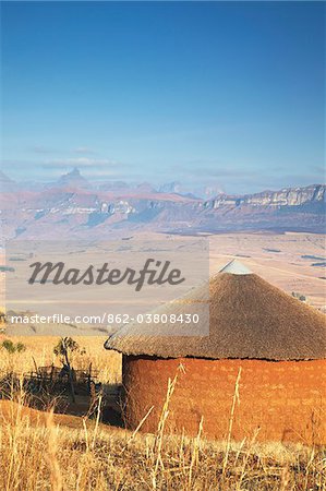 Cabane de village avec la pointe de la cathédrale en arrière-plan, Ukhahlamba Drakensberg Park, KwaZulu-Natal, Afrique du Sud Cabane de village avec la pointe de la cathédrale en arrière-plan, Ukhahlamba Drakensberg Park, KwaZulu-Natal, Afrique du Sud