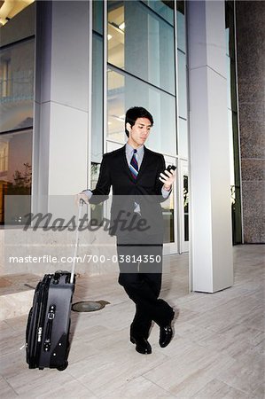 Homme d'affaires avec téléphone cellulaire et valise