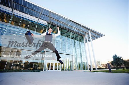 Businessman Leaping in front of Building