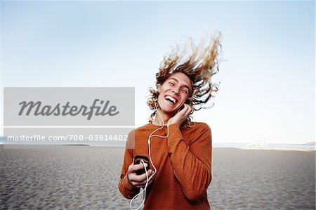 Young Man Listening to Music on Beach