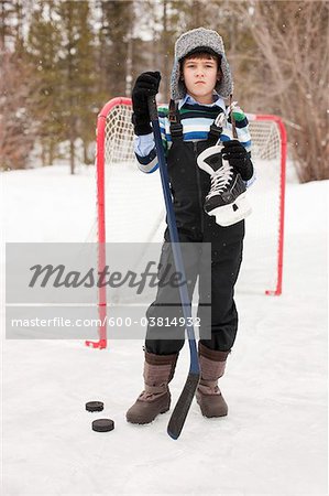 Boy Holding Hockey Skates and Hockey Puck, Frisco, Summit County, Colorado, USA