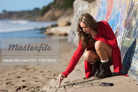 Woman Drawing in Sand