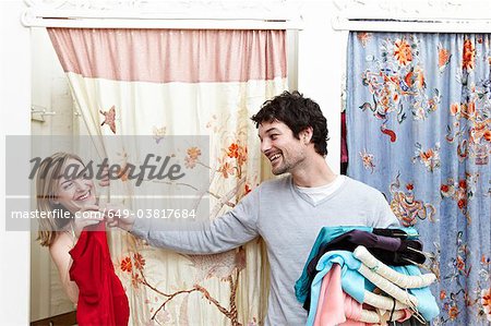 Man holding clothes by a changing room