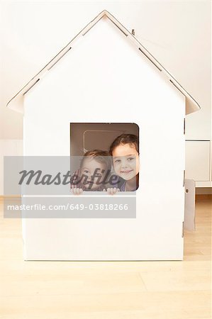 Boy and girl in cardgoard house