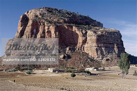 Près de Degum, les peuplements d'église de delporte rupestres au sommet d'un massif, qui fait partie des montagnes de Gheralta spectaculaire du Nord Ethiopia.A tigré homestead se trouve sur la plaine aride de Hawzien des centaines de mètres plus bas. Plats maisons en pierre avec toiture, qui sont communes dans la Province du Tigré, peuvent avoir été introduites en Éthiopie d'Arabie 700 ans avant j.-c..