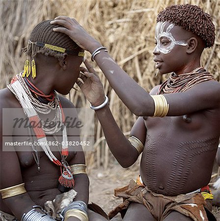 Karo filles peignent leurs visages en préparation pour une danse. C'est une tradition pour les filles de percer un trou en dessous de la lèvre inférieure dans laquelle ils placent un morceau de métal mince ou un clou pour la décoration. Scarification élaborée n'est pas une forme inhabituelle de décoration de corps.Le Karo sont une tribu vivant dans trois villages principaux le long du cours inférieur du fleuve Omo en Éthiopie.