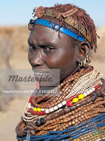 Une femme de Nyangatom porte de nombreux brins de perles en bois.Le Nyangatom sont une des plus grandes tribus et sans doute les plus belliqueuses de personnes vivant le long de la rivière Omo en Éthiopie. Ils forment une partie du peuple francophone Ateger un groupe de sept tribus nilotiques orientales auquel appartiennent les Turkana du Kenya du Nord et les Karamajong du nord-est de l'Ouganda.