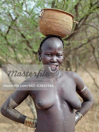 Femme Mursi portant une argile grande plaque les lèvres et ornements pour correspondre à l'oreille.Peu de temps avant le mariage, une lèvre supérieure filles est percée et progressivement tendue sur un an ou deux, alors que certains de ses dents sont supprimées pour la plaque être bien ajusté. La taille de la plaque de lèvre détermine souvent le montant de la dot. La raison de cette pratique singulière n'est pas entièrement comprise, mais les femmes Mursi