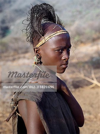 Kenia, South Horr, Kurungu.A Samburu Jugend nach seiner Beschneidung. Am Tag nachdem er beschnitten worden ist, muss das eingeführte in seinem durchbohrten Ohrläppchen Kupfer Ohr Ornamente hängen, die normalerweise von verheirateten Frauen getragen werden. Seine Sponsoren machen ihn zu einer neuen Kopfschmuck von Straußenfedern befestigt, ein schmales Band geflochtene Faser, die Runde Stirn wie ein Schweißband eng passt.