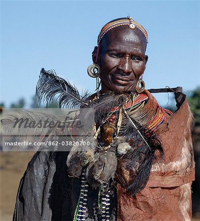 A proud Samburu mother of two recently circumcised boys wears briefly their bird skin headdresses round her neck after they discard them during the lmuget loolbaa ceremony a month after their circumcision. She in turn will throw them away the same evening and ensure the familys cattle trample them under foot so that they will never be used or seen in public again.