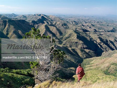 Un guerrier Samburu donne sur une vaste étendue de pays inhospitalier de l'escarpe orientale d'Afriques grande vallée du Rift au Losiolo, au nord de Maralal. De 8 000 pieds la terre s'engouffre à 3 000 pieds dans vallées accidentées et une large plaine, le domaine des pasteurs nomades, avant la hausse de plus de 75 km.