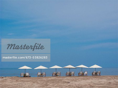 row of beach chairs and umbrellas