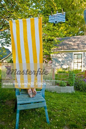 boy on garden chair under beach towel