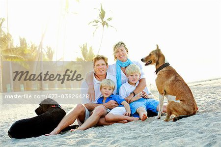 Portrait de famille sur la plage avec les chiens