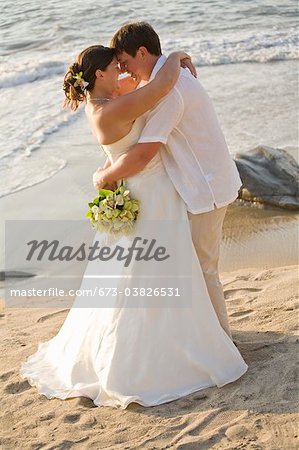 bridal couple hugging on beach