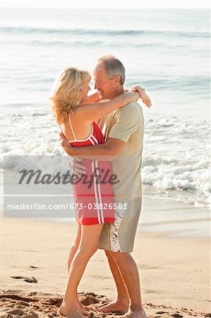 mittleren Alter paar umarmt am Strand
