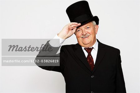 A smiling man in a suit and a hat.