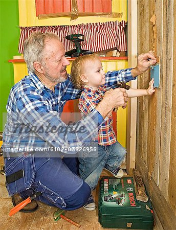 Un homme senior fait la menuiserie avec son petit-fils, Suède.