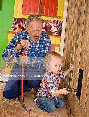 Un homme senior fait la menuiserie avec son petit-fils, Suède.