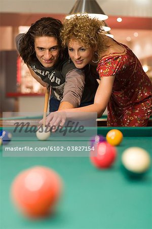 Un homme et une femme jouant au billard de poche.