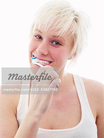 A Scandinavian teenage girl brushing her teeth.