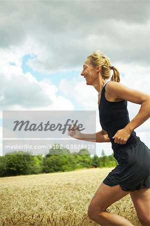 Femme jogging dans un paysage ouvert, Suède.