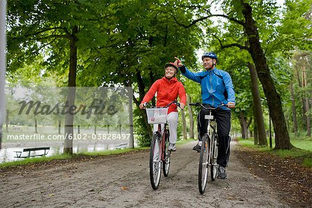 A couple cykling in a park, Sweden.