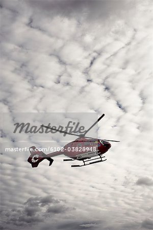 An ambulance helicopter against a cloudy sky, Sweden.