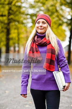 A woman walking in a park in autumn, Sweden.
