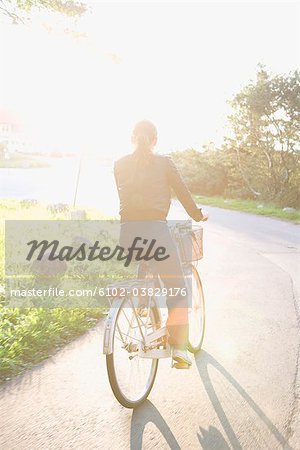 Femme, faire du vélo à contre-jour, Suède.