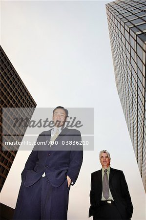 Businessman Standing near Skyscrapers