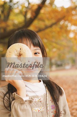 Preteen Girl Looking Trough Hole In Bagel