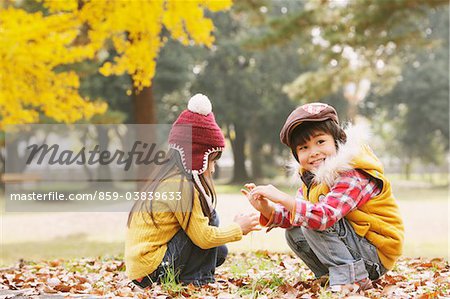 Garçon et fille assise dans les feuilles d'automne