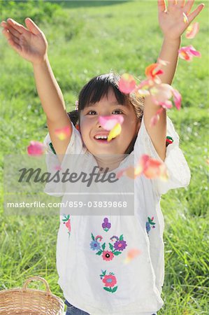 Jeune fille jetant des pétales de fleurs