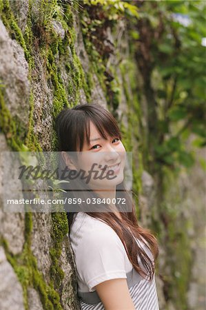 Young adult woman Leaning against wall