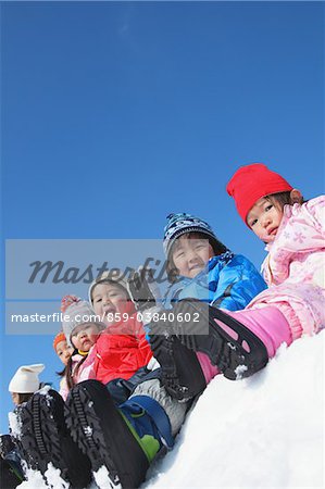 Enfants assis ensemble dans la neige