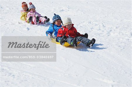 Children Sledging In Snow