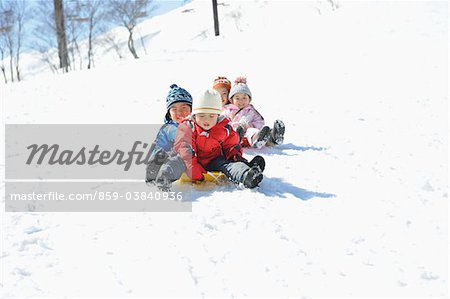 Children Sledging In Snow