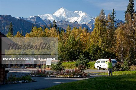 Woman visitor takes photographs the southside view of Mt. Mckinley and Alaska Range from the Alaska Veteran's Memorial rest area along George Parks Highway, Denali State Park, Southcentral Alaska, Autumn