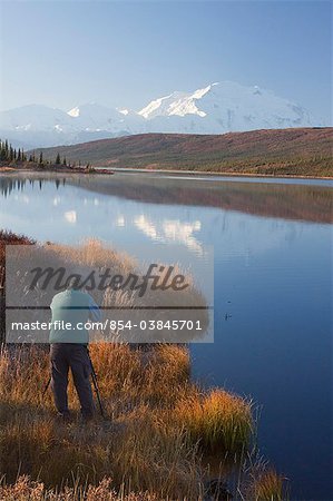 Man photographs the northside of Mt. McKinley from Wonder Lake in Denali National Park and Preserve, Interior Alaska, Fall