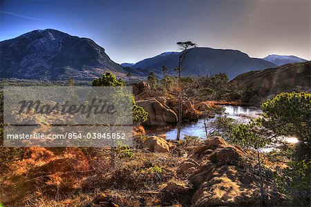 Scenic view of Annette island and surrounding coastal area with male hiker in the foreground, Inside Passage, Southeast Alaska, Spring. HDR