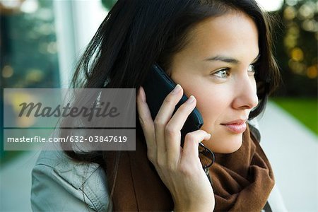 Jeune femme à l'aide d'un téléphone cellulaire, portrait